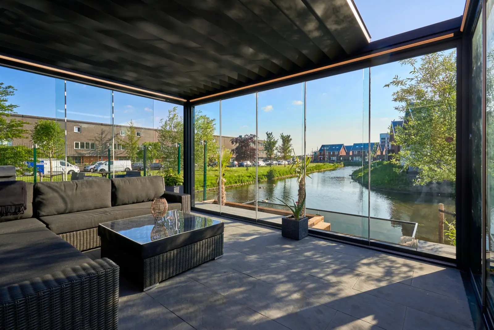 Louvered pergola enclosed with sliding glass walls, looking out over water