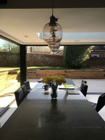 Dining table in the new extension, garden through the glass