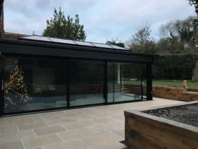 Dark-framed glass extension at dusk