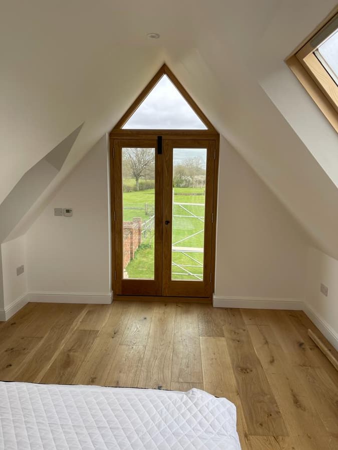 Loft bedroom with oak doors in the gable