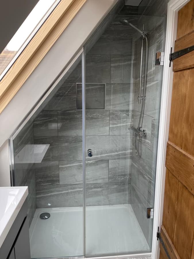 Shower tucked under the sloping loft ceiling