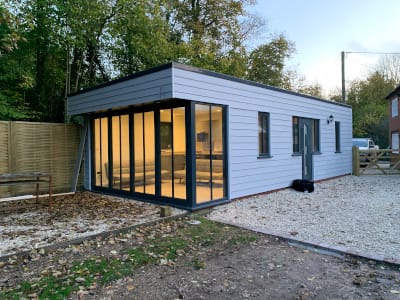 White-clad single-storey annexe with bifold doors