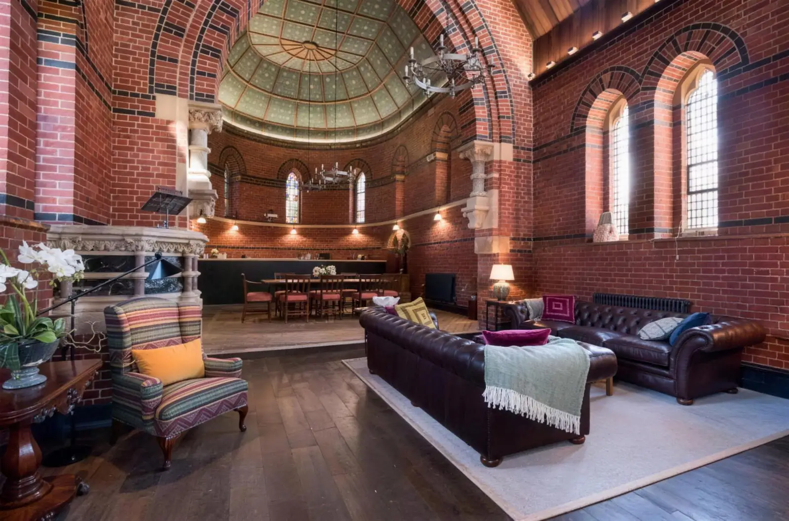 Open-plan living space beneath a painted dome in a converted Victorian chapel