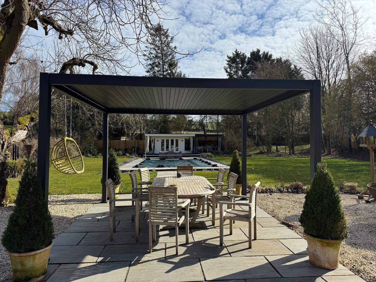 Dark aluminium pergola over patio dining area